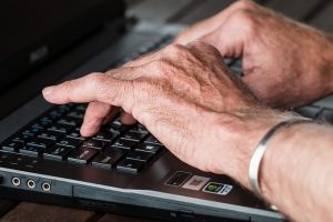 高齢者がキーボードを打つ
